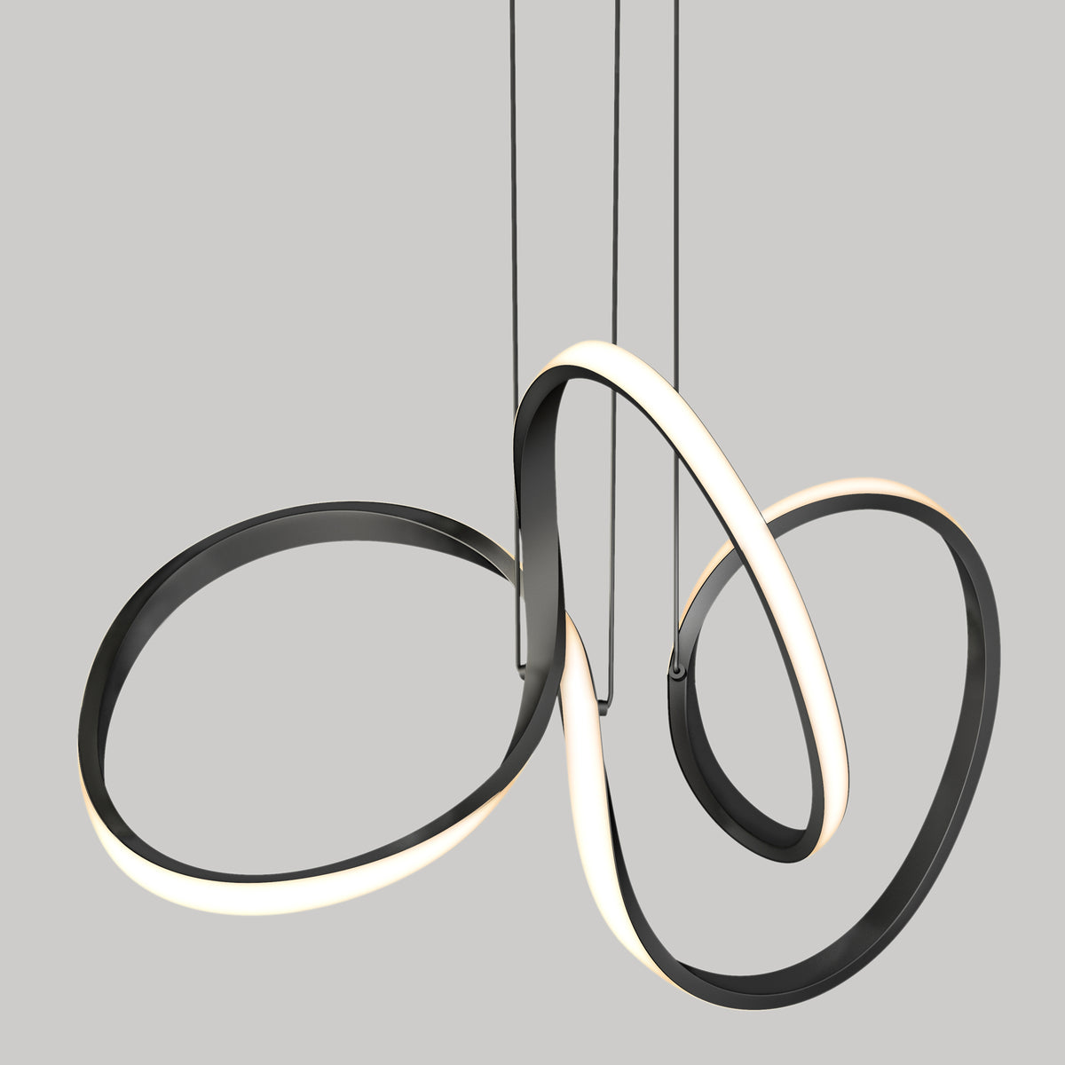 A modern pendant light fixture with three intertwined, looping LED strips, featuring a sleek black frame and glowing white edges, suspended by thin cables against a plain gray background.