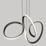 A modern pendant light fixture with three intertwined, looping LED strips, featuring a sleek black frame and glowing white edges, suspended by thin cables against a plain gray background.