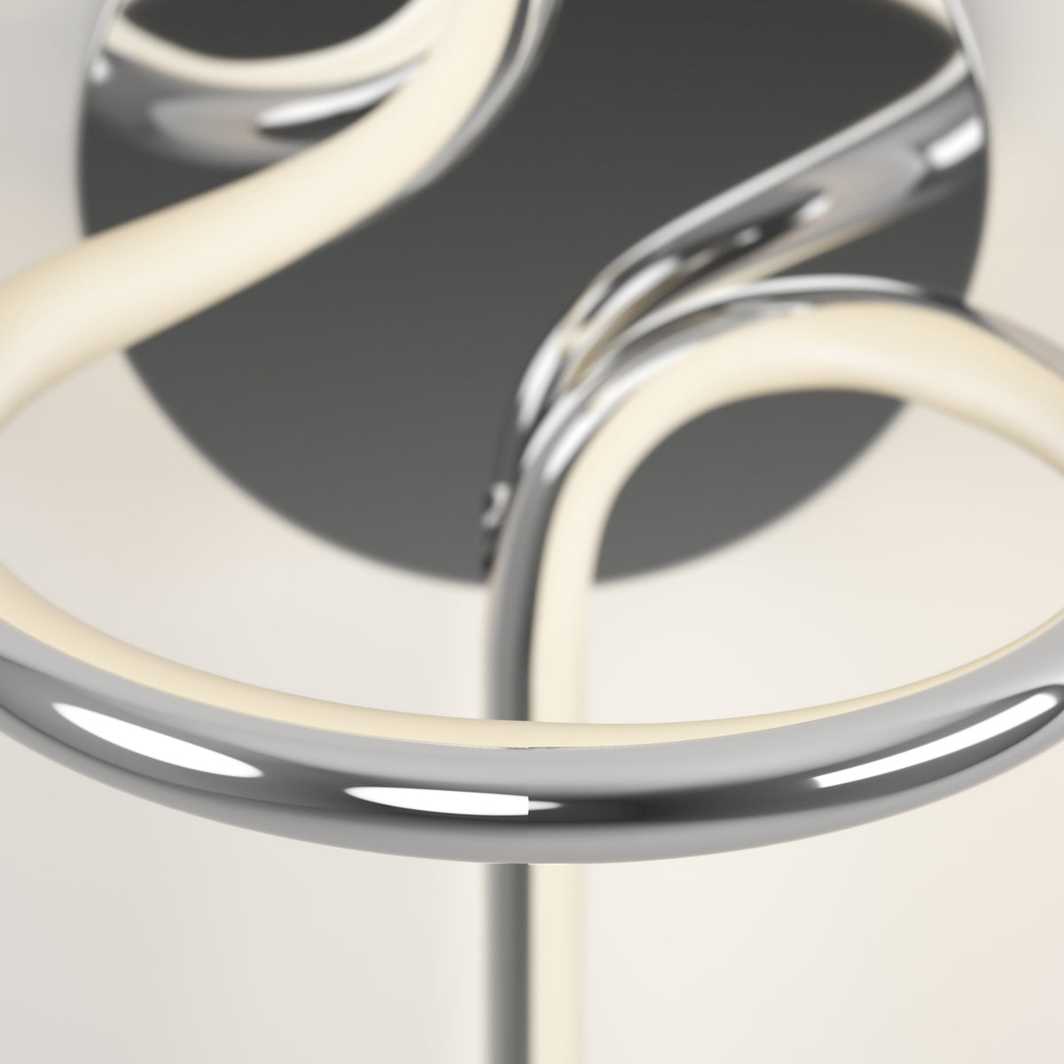 Close-up of the Artika Swirl LED Sconce, featuring modern chrome and white curved tubes in an abstract design against a soft, neutral background.