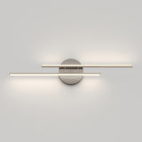 A modern wall-mounted light fixture with two horizontal, parallel LED bars extending from a round metallic base, casting soft light on a plain white wall.