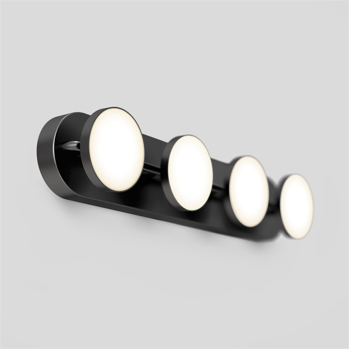 A modern wall-mounted light fixture with four evenly spaced, round, illuminated bulbs on a sleek black base against a plain light gray background.