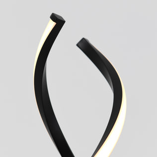 The Artika Swirl LED table lamp features two black, curved arms with glowing white LED strips, showcased against a plain light gray background.