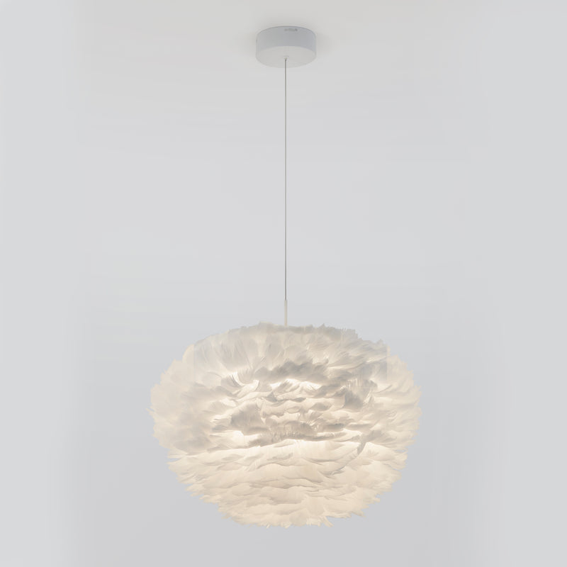 The Artika Plume LED pendant light features a spherical shade crafted from layered, feather-like white material and hangs elegantly from the ceiling by a thin cord against a plain white background.