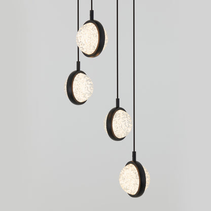 Four modern pendant lights with round, textured glass shades and black frames hang at different heights against a plain light gray background.