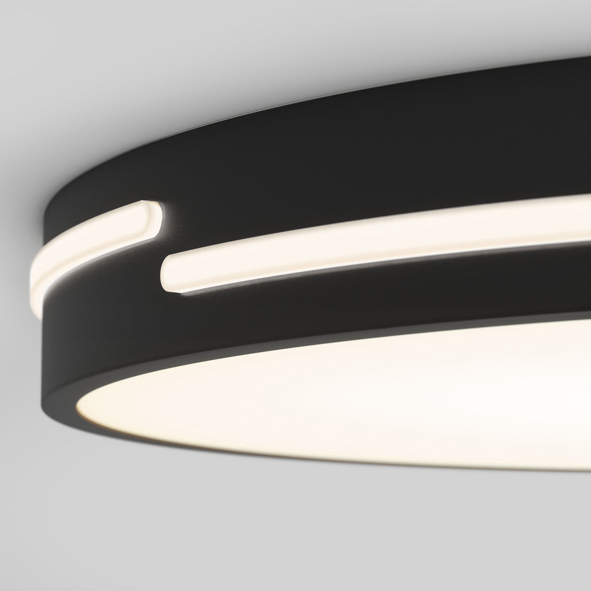 Close-up of a modern, circular ceiling light with a black frame featuring an illuminated white strip around its edge, displayed against a light gray background.