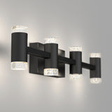 A modern black wall-mounted light fixture with four cylindrical lights, each with clear ends featuring small bubble-like details, is illuminated against a light gray wall.