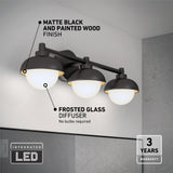 A modern bathroom wall light with three round frosted glass diffusers, matte black and painted wood finish. Integrated LED, no bulbs required. “3 years warranty” is noted in the bottom right corner.
