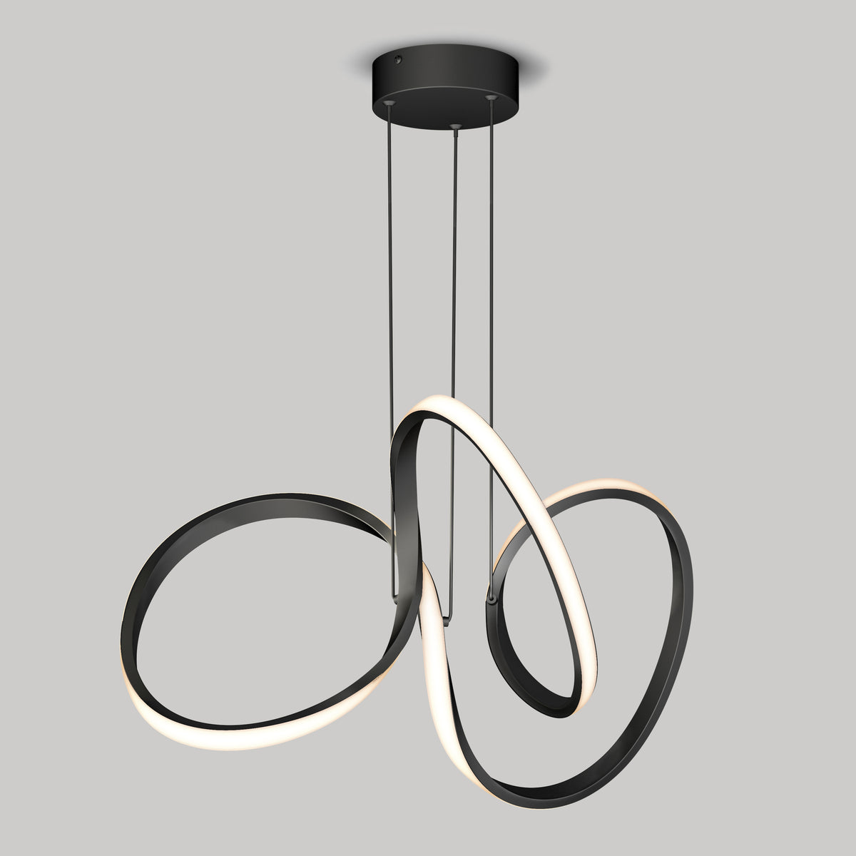 The Artika Swirl LED pendant light features three interlocking, twisting black and white loops suspended by cables from a circular black ceiling mount against a plain gray background.