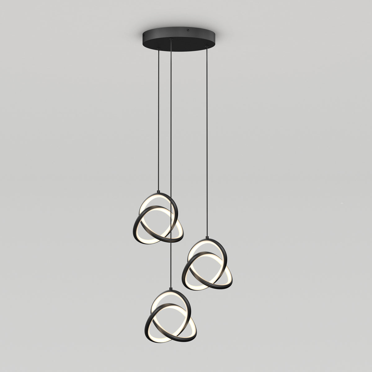 The Artika Zephyr 3-light LED pendant features three black rings with illuminated inner edges, intertwined and suspended from a round black ceiling mount by cords for a modern look.