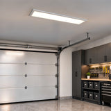 An Artika Sunray 48 in. x 12 in. ultra-thin LED ceiling light panel installed in a garage.