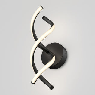 The Artika DNA modern LED wall sconce 3 CCT features two twisted tubes—one black, one glowing white with integrated LEDs—mounted on a round black base against a plain light gray background.