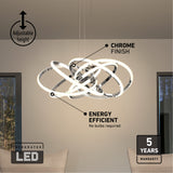 A modern, chrome-finish LED chandelier with interlocking rings hangs above a dining table. Labels highlight its adjustable height, energy efficiency, chrome finish, integrated LED, and 5-year warranty.