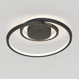 A modern, circular ceiling light fixture with a dark, metallic frame and integrated LED ring, mounted on a plain white ceiling. The fixture emits a soft, even glow around its circular edge.