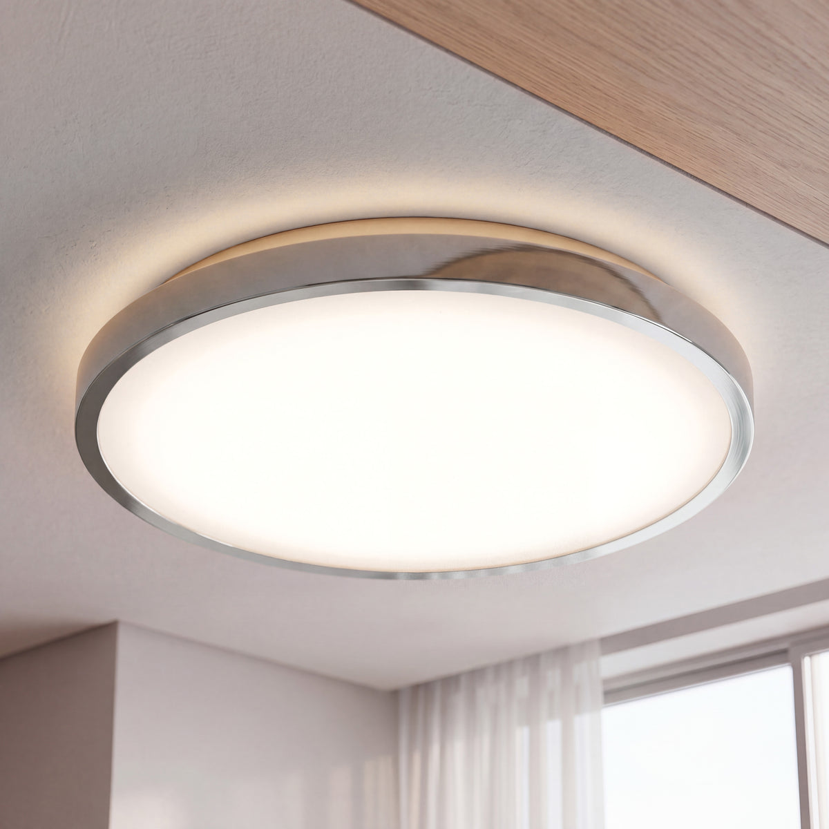 Artika Isara 12″ RGBIC LED Flush Mount with interchangeable trim, shown on white ceiling by window with sheer curtains.