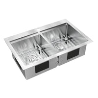 The Artika Newport twin bowl 33 in. stainless steel workstation sink features a flat rim, two metal grids (one per basin), and a faucet hole centered on the back edge.