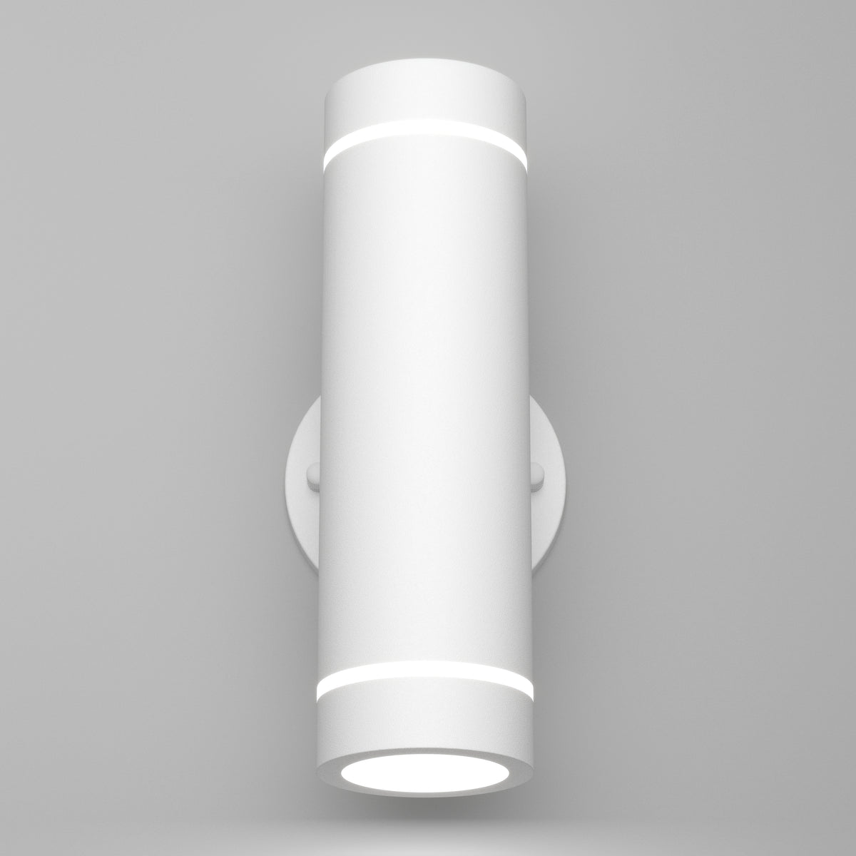 The Artika C7 indoor-outdoor LED wall light 3 CCT is a modern cylindrical white sconce with subtle circular bands, mounted on a round base against a plain light gray wall.