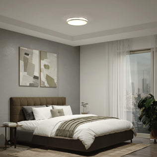 Modern bedroom with a neatly made bed, abstract art, large window, and Artika Hemisphere 15 in. Modern LED Flush Mount Ceiling Light.