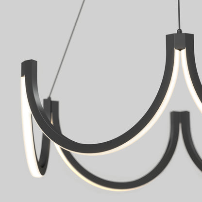 A close-up of the Artika Adelia LED pendant light 5 CCT, a modern black chandelier with curved arms and integrated lighting, suspended from the ceiling against a plain light gray background.