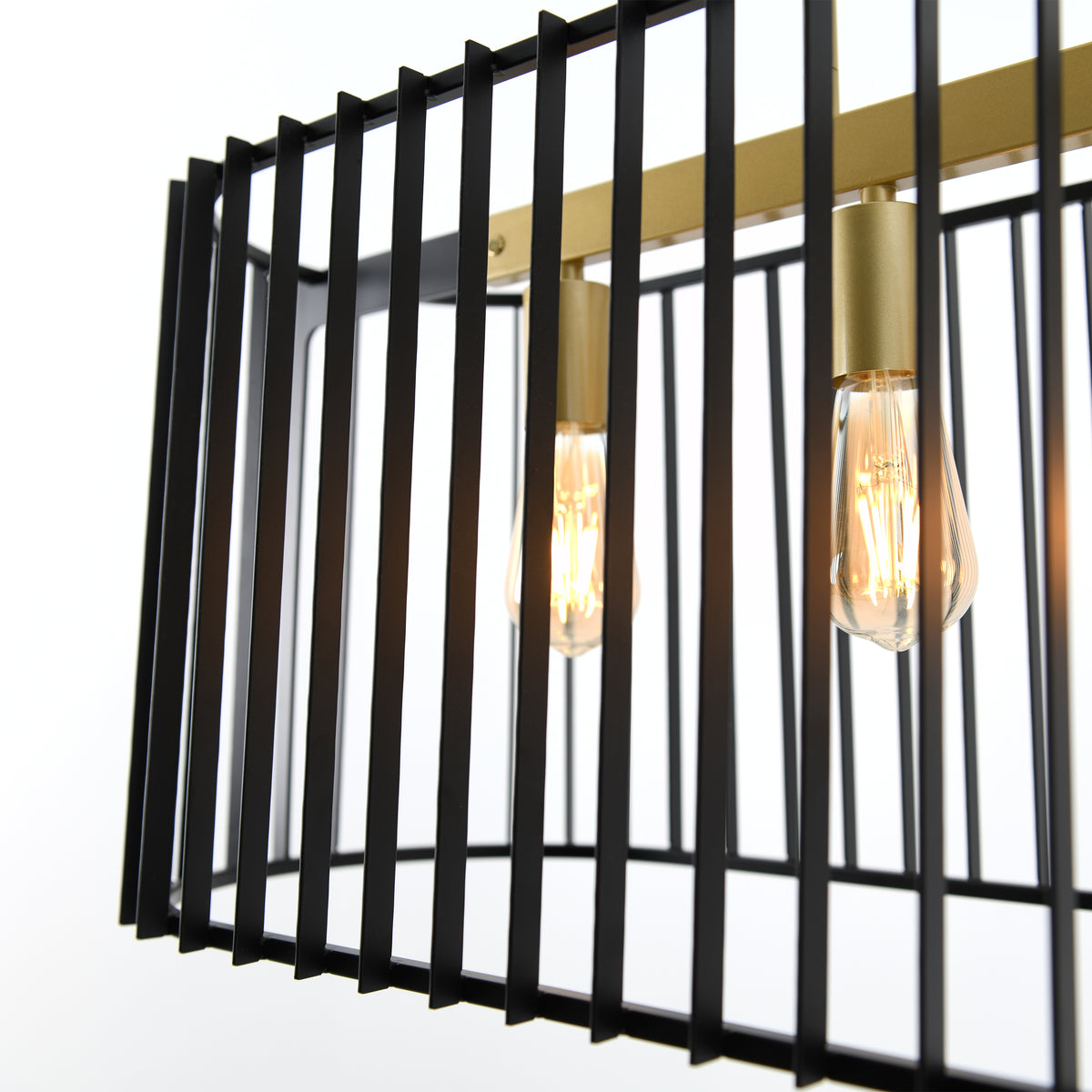Close-up of a modern light fixture featuring exposed Edison bulbs and a rectangular black metal cage with vertical bars, accented by gold-toned hardware.