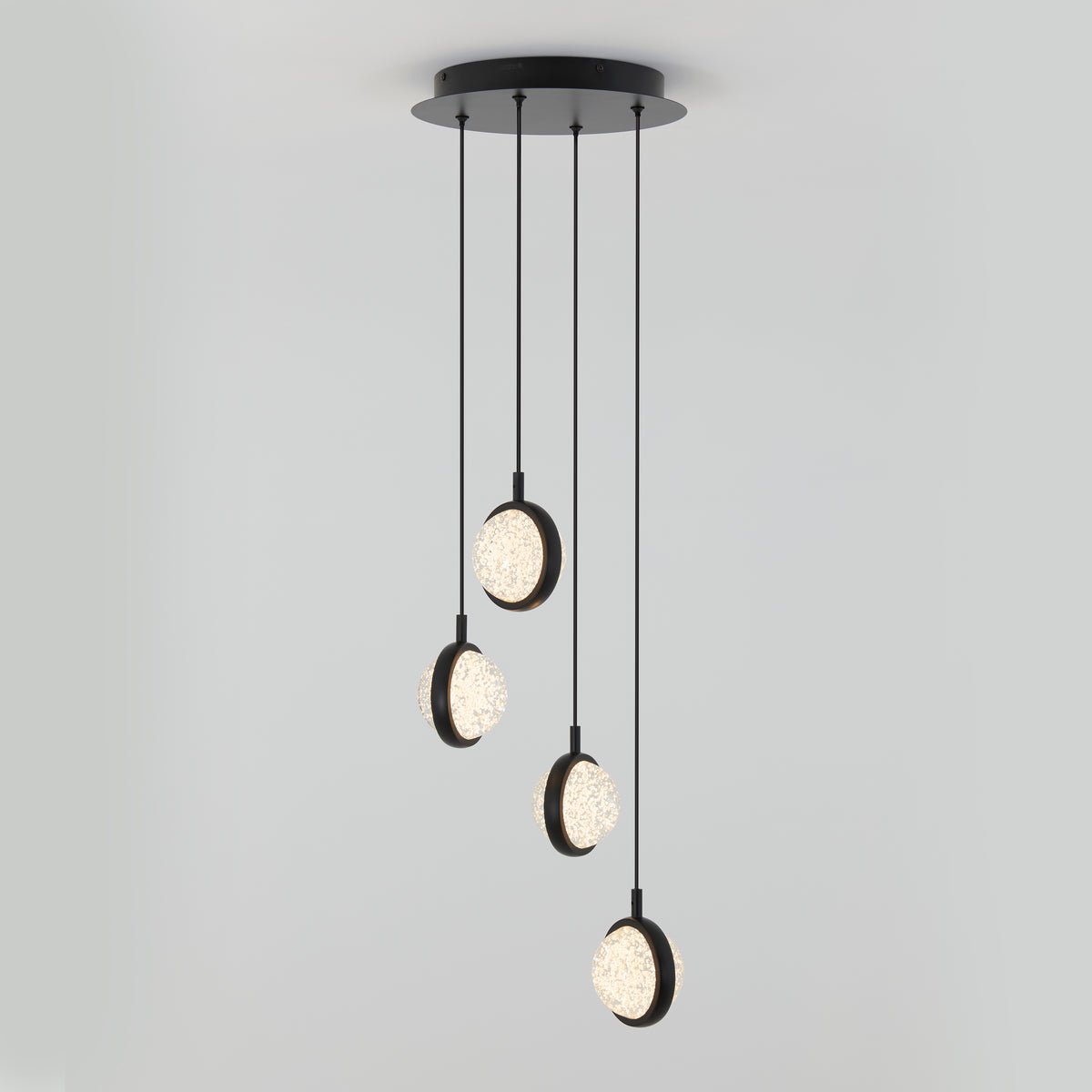 The Artika Avalon 4-light LED pendant features four crystal-like circular lights suspended at different heights from a round black base, creating a striking modern centerpiece against a white background.