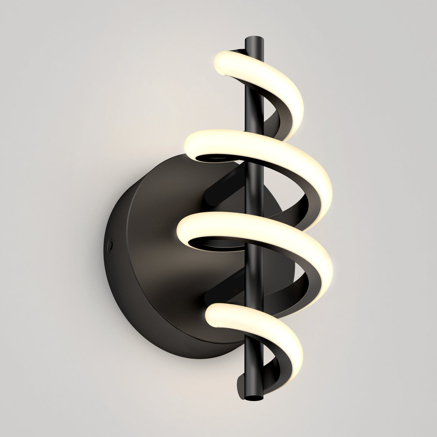 The Artika Chorus LED Wall Light features a black circular base and vertical rod wrapped with two spiral LED tubes, emitting a soft white glow, shown mounted on a light gray wall.