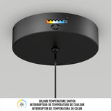 A black ceiling light fixture with a color temperature switch displaying five adjustable color temperature options, labeled with a gradient from warm yellow to cool blue, and a button beneath the indicator.
