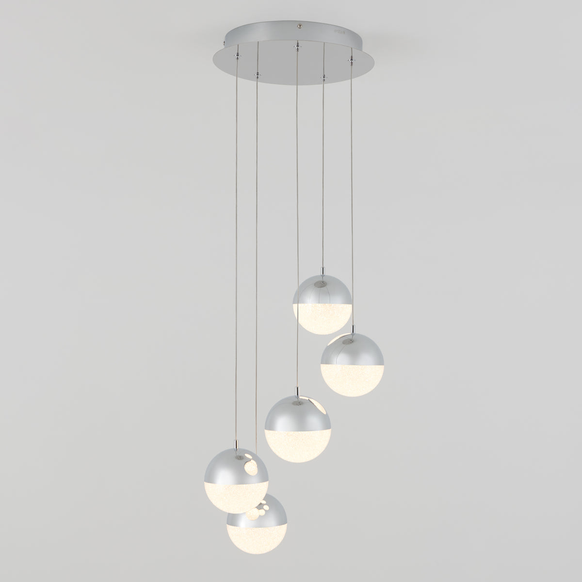 The Artika Sparkle 5-light LED pendant features five spherical silver and white lamps suspended at varied lengths from a round ceiling mount, offering a modern design against a plain white background.