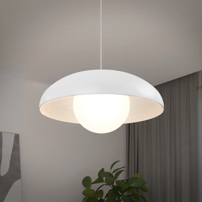 The Artika Boden LED modern mid-century pendant light 3 CCT features a white dome-shaped shade and glowing bulb, hanging in a stylish room with gray curtains, a plant, and abstract wall art.