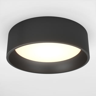 The Artika Alton LED flush mount is a modern circular black ceiling light with a wide rim and glowing white center, designed for flush mounting on a white ceiling.