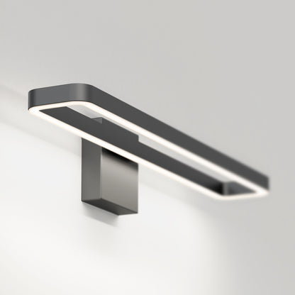 The Artika Hinge LED modern bathroom vanity light 3 CCT features a minimalist rectangular design with a black frame and glowing white edge, mounted on a gray base, perfect for contemporary spaces.