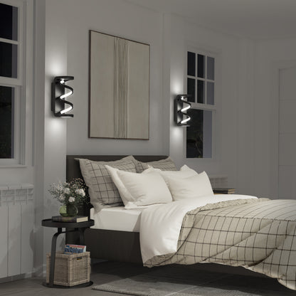 A modern bedroom with a neatly made bed, plaid bedding, two Artika Swirl indoor-outdoor LED wall lights, a round nightstand with a basket below, and minimalist art above the headboard.