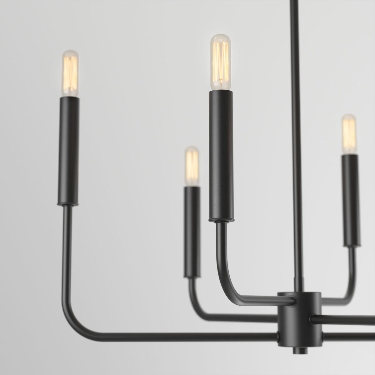 The Artika Manchester 6-light pendant features a minimalist black metal design with exposed bulbs on straight arms, displayed against a plain light gray background.