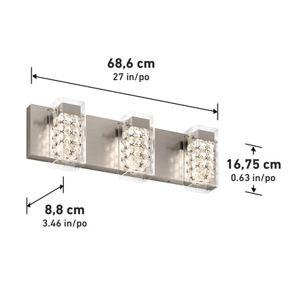 A three-light wall vanity fixture with crystal glass shades, brushed metal base, and dimensions labeled: 68.6 cm wide, 16.75 cm high, and 8.8 cm deep. Measurements shown in both cm and inches.