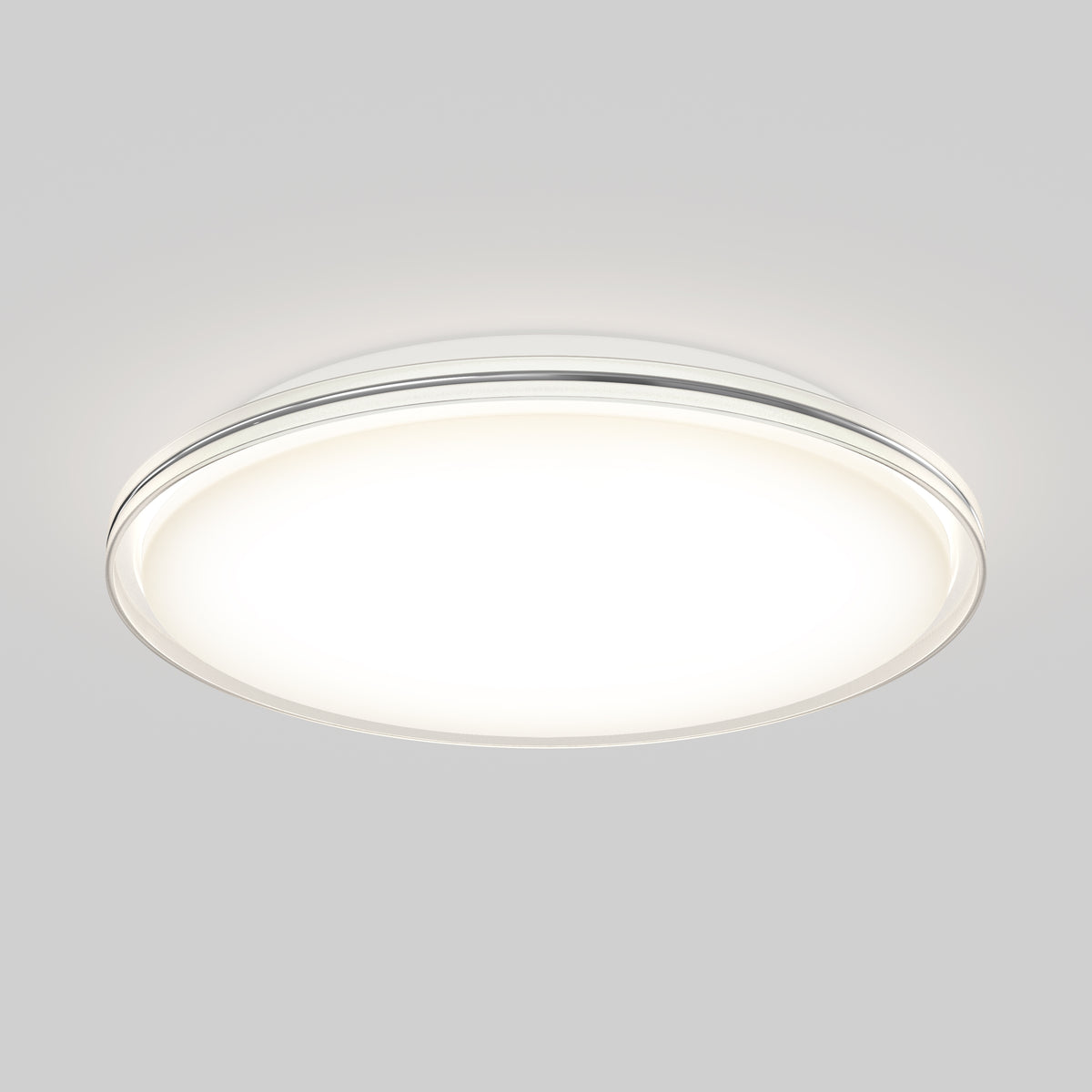 A modern, round ceiling light fixture emits a soft, bright white glow against a neutral gray background.