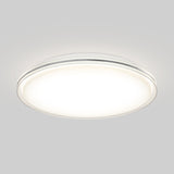A modern, round ceiling light fixture emits a soft, bright white glow against a neutral gray background.