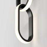 A close-up of modern, black and white illuminated chain links fixed to a light-colored wall, forming a minimalist and sleek decorative light fixture.