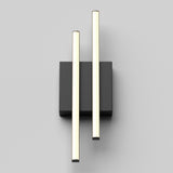 A modern wall light fixture with two parallel, vertical, glowing rods mounted on a rectangular black base against a light gray background.