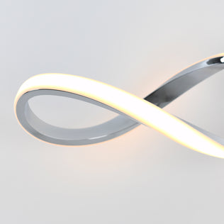 The Artika Swirl modern LED bathroom vanity light features integrated LEDs in an infinity-inspired design with a sleek metallic finish, softly illuminating against a plain white background.