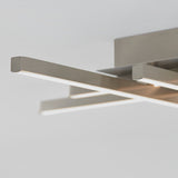 Close-up of a modern ceiling light fixture with three sleek, horizontal metal bars emitting light, set against a plain, light-colored background.