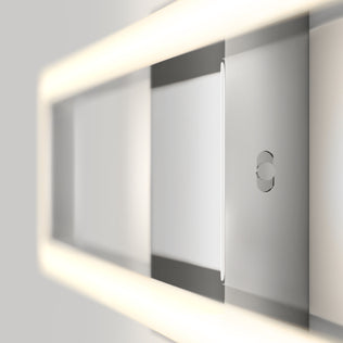 A close-up of Artika’s Dover modern LED bathroom vanity light 5 CCT, featuring a sleek rectangular design with soft built-in LED lighting along the edges and a small circular detail, mounted on a light gray wall.
