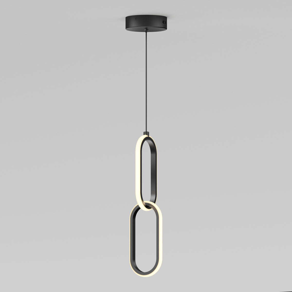 The Artika Catena LED pendant light features two intersecting oval LED rings hanging vertically from a black ceiling mount, showcasing a sleek, modern design. Adjustable to 5 CCTs, its perfect for minimalist interiors.
