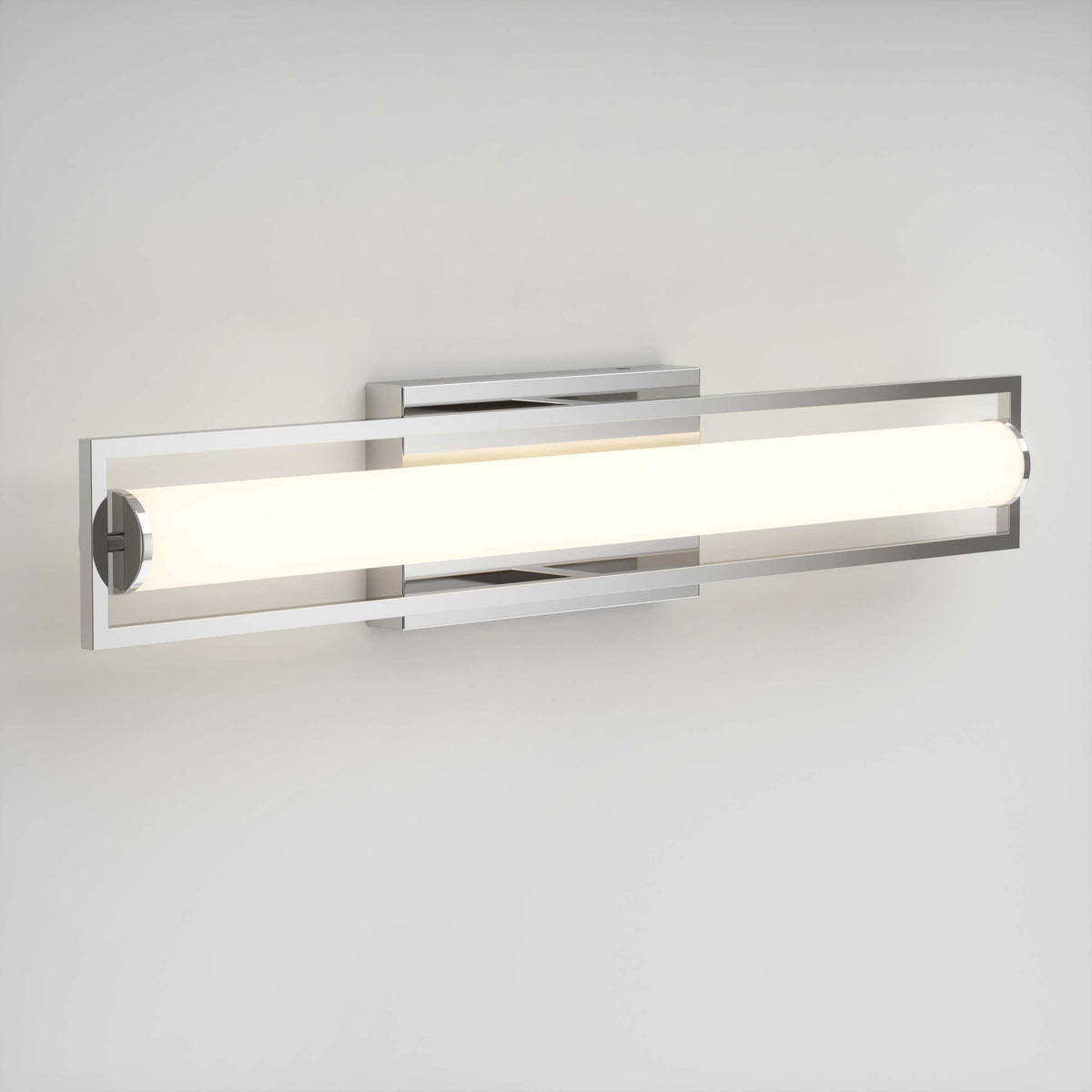 A modern wall-mounted light fixture with a horizontal frosted tube, framed by a sleek metallic rectangular border, emits a bright, even glow against a plain white wall.