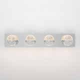 A modern wall-mounted light fixture with a rectangular chrome base and four round, illuminated glass globes evenly spaced in a row. The globes have a textured inner surface, casting a soft glow.