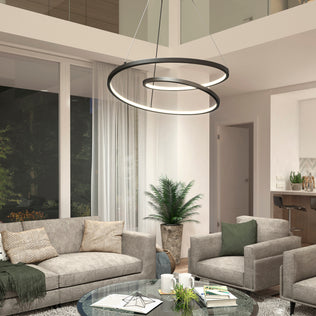 Modern living room featuring gray sofas, armchairs, a round glass coffee table, and the Salto LED pendant light by Artika. Large windows with sheer curtains and a potted plant bring natural touches to this contemporary space.