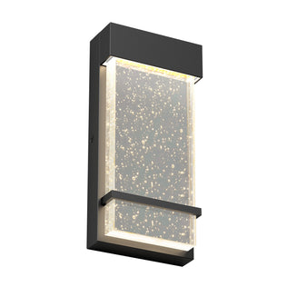 The Skyler indoor-outdoor LED wall light by Artika features a modern rectangular matte black frame and a clear bubble-embedded panel, glowing with soft white LED illumination.