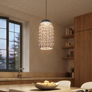 A modern kitchen features the Artika Benson Mini LED pendant light 5 CCT above a counter with a bowl of apples. Wooden cabinets, open shelves, a sink, and a large window with views of trees create a cozy, minimalist space.