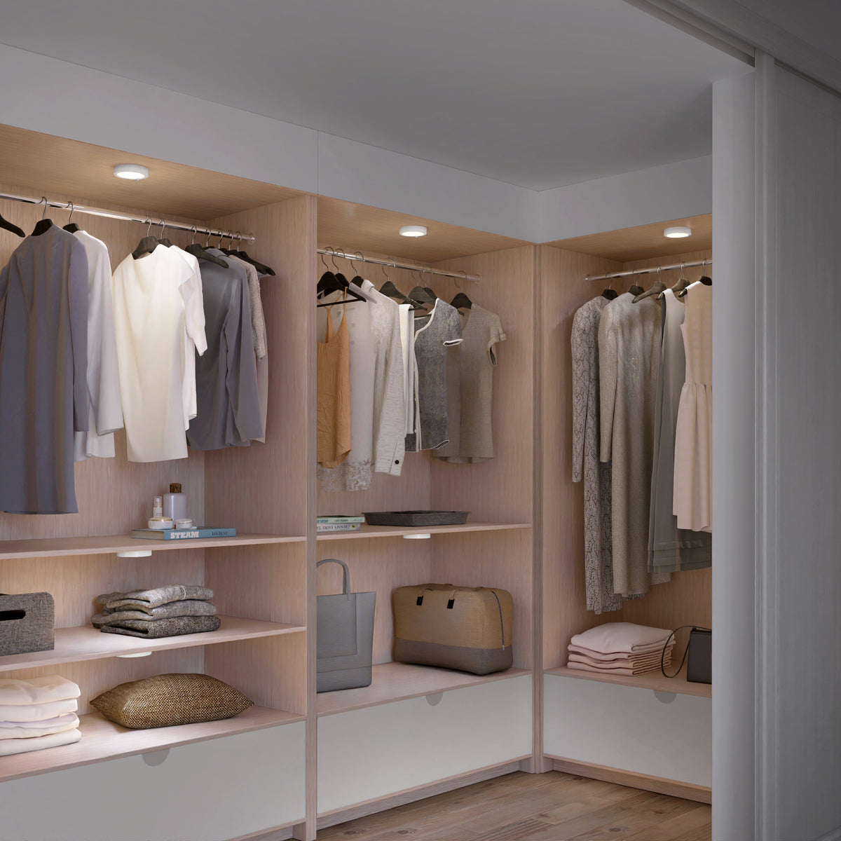 A modern, organized walk-in closet with wooden shelves and hanging rods. Clothes in neutral tones are neatly hung, and shelves hold folded items, bags, and accessories. Recessed lights illuminate the space.