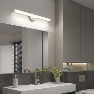 Modern bathroom with a wide mirror, sleek vanity, Artika Ewen LED light, faucet, soap dispenser, and plant by the sink.