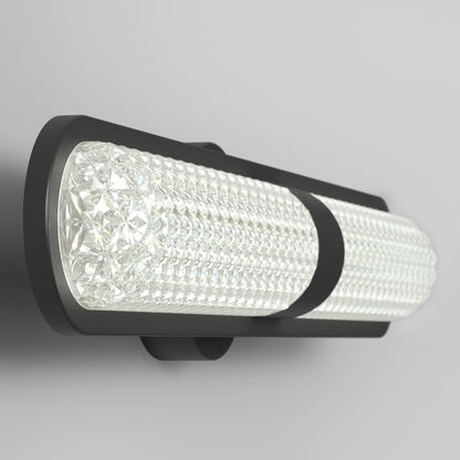 The Artika Carat LED contemporary bathroom vanity light 3 CCT features a black frame and textured cylindrical glass, offering modern style and adjustable color temperature, and is shown mounted on a light gray wall.