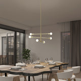 A modern dining room with a live-edge wooden table set for six, white chairs, a contemporary gold chandelier with globe lights, large windows, and sheer curtains.